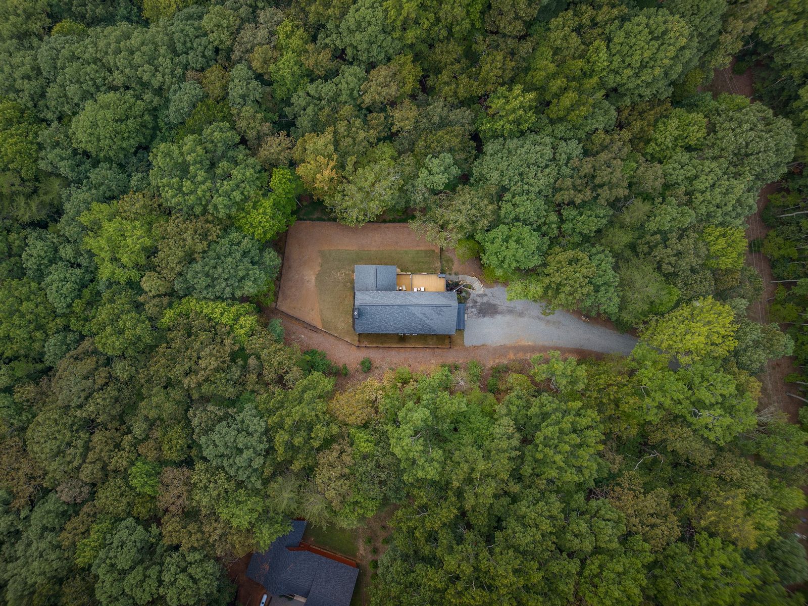 Aerial view of the home surrounded by forest
