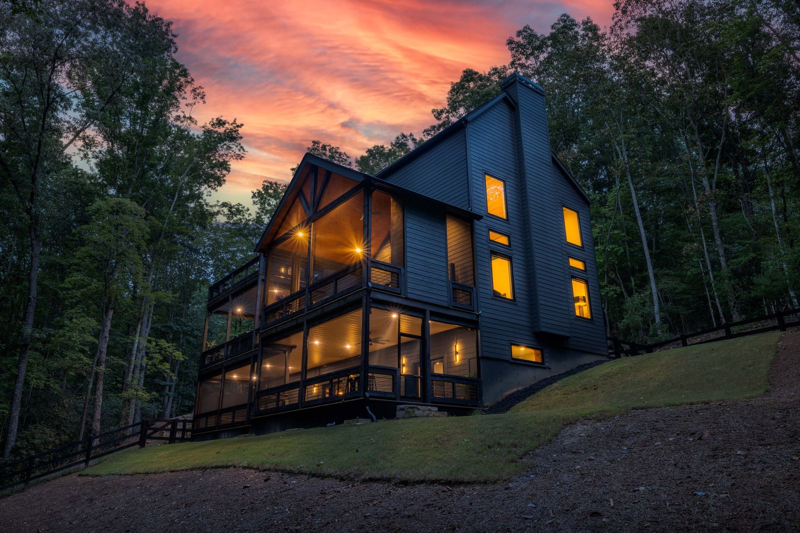 63 Laurel Trace at twilight, glowing through floor-to-ceiling glass